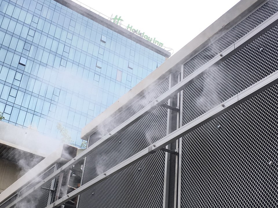 Industrial precooling system with water mist nozzles operating in a hot environment